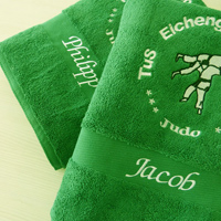 Badetücher mit Logo besticken Grünes Badetuch mit Vereinslogo und einzelnen Namen bestickt in weiss, schwarz