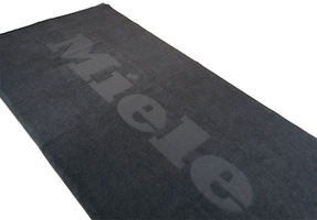 Handtuch mit Logo-einwebung dunkelgraues Handtuch mit Miele Logo einwebt hoch/tief, 3d vollflächig, Reliefeinwebung